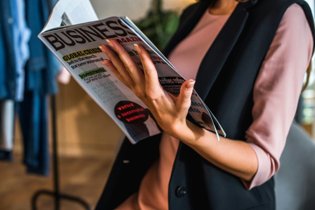 close-up partial view of young woman reading business magazine